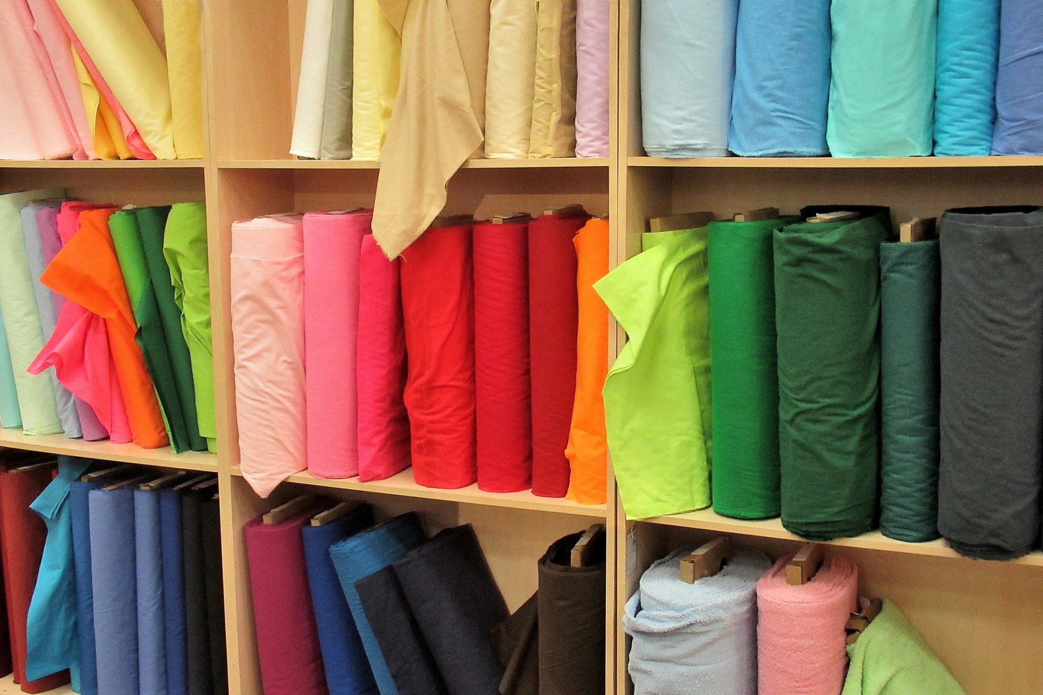 Shelves of colorful fabric bolts in a showroom