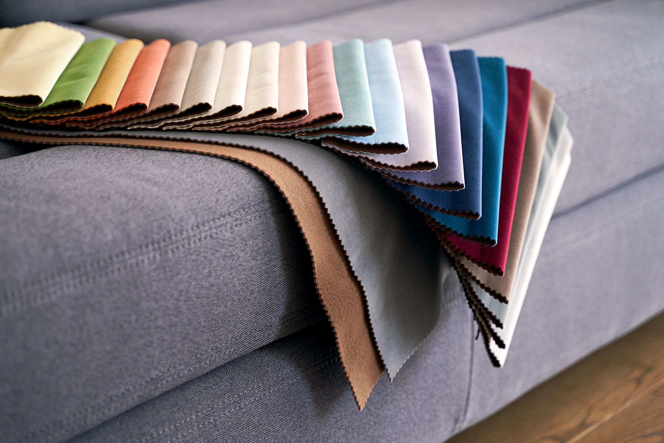 Colorful upholstery fabric samples arranged on a sofa
