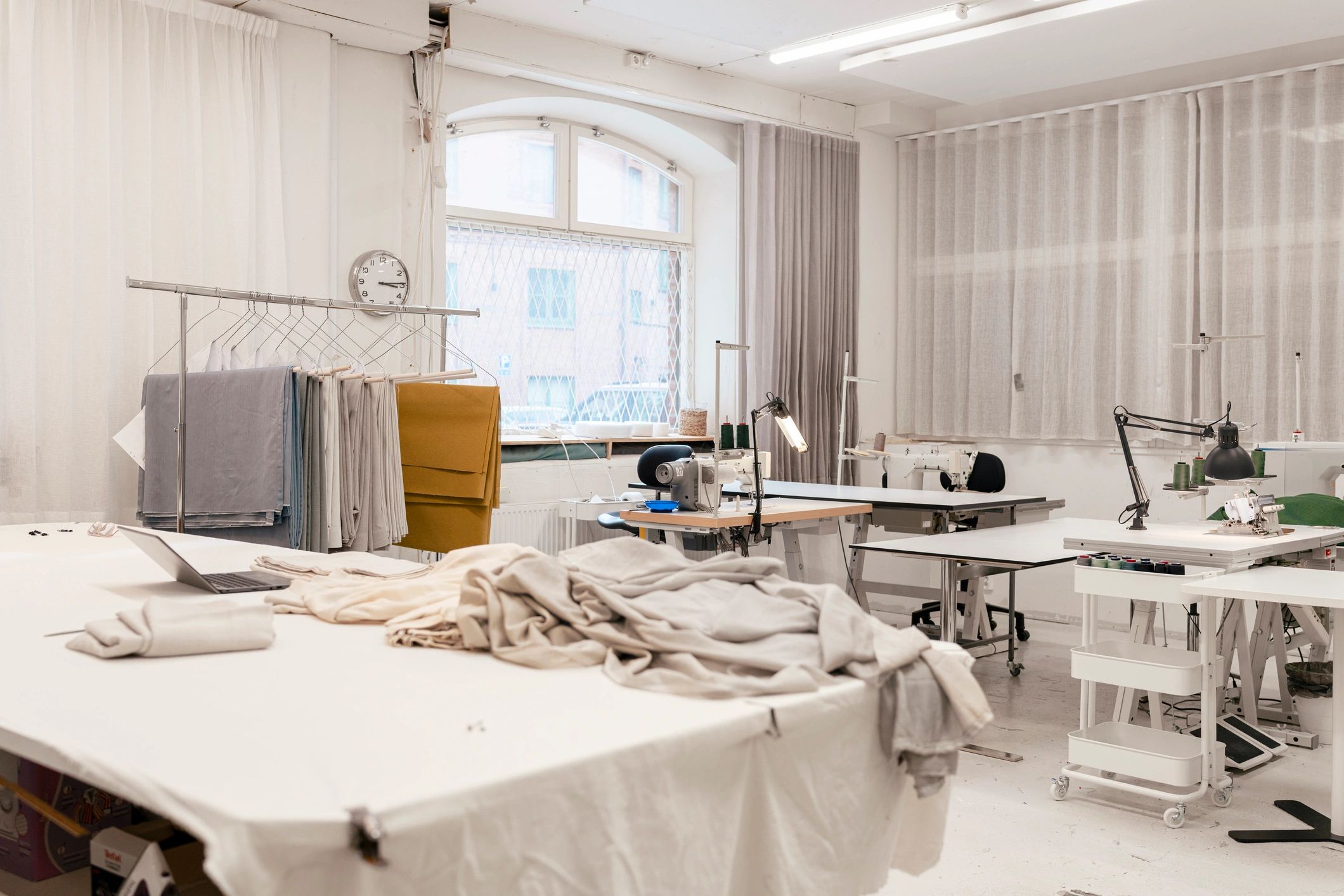 Organized sewing workshop studio with fabrics and industrial machines